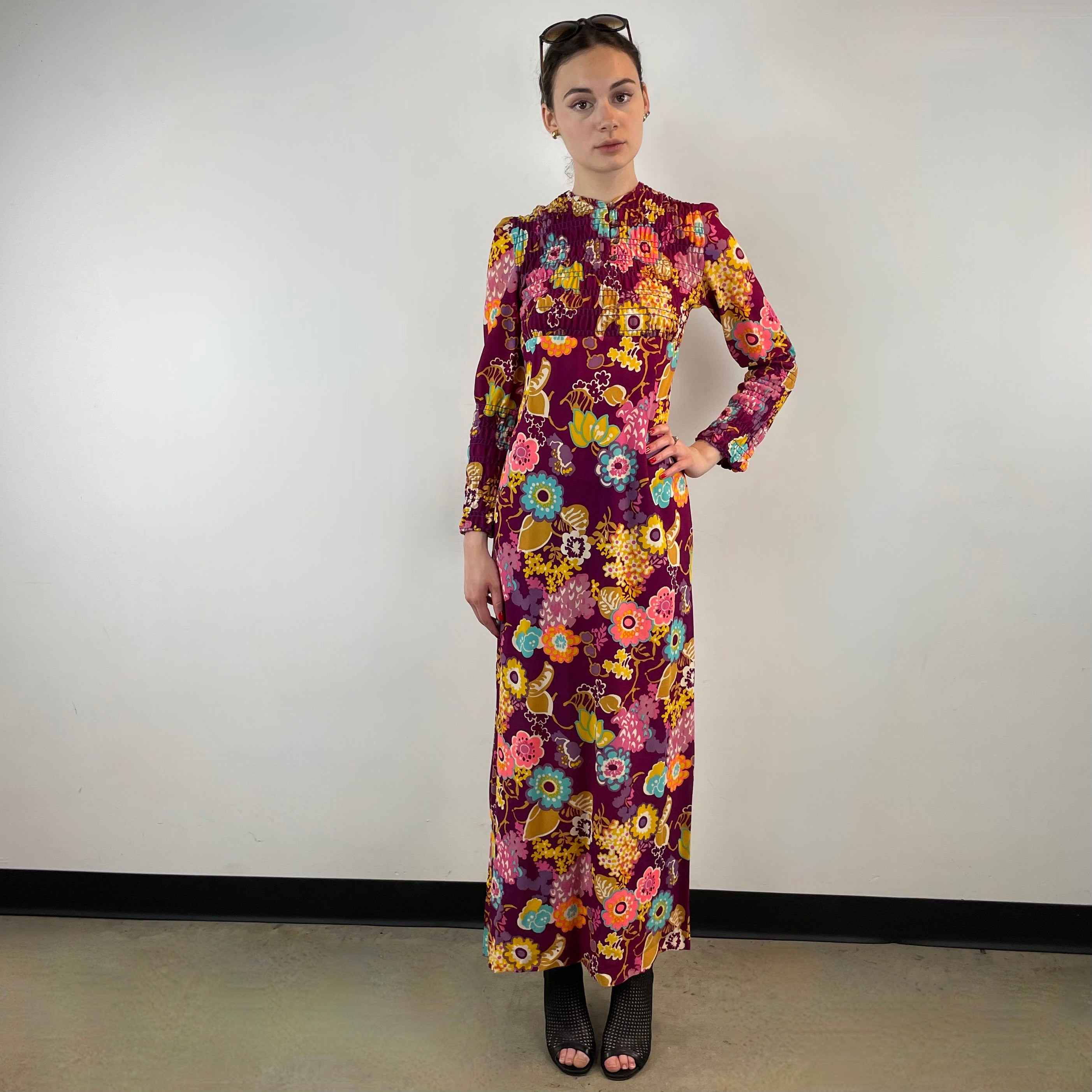 Front view of 1970s floral empire waist maxi dress with ruched bodice, high neckline and long ruched sleeves in bold print lightweight fabric – Boheme Vintage Montreal https://bohemevintage.com