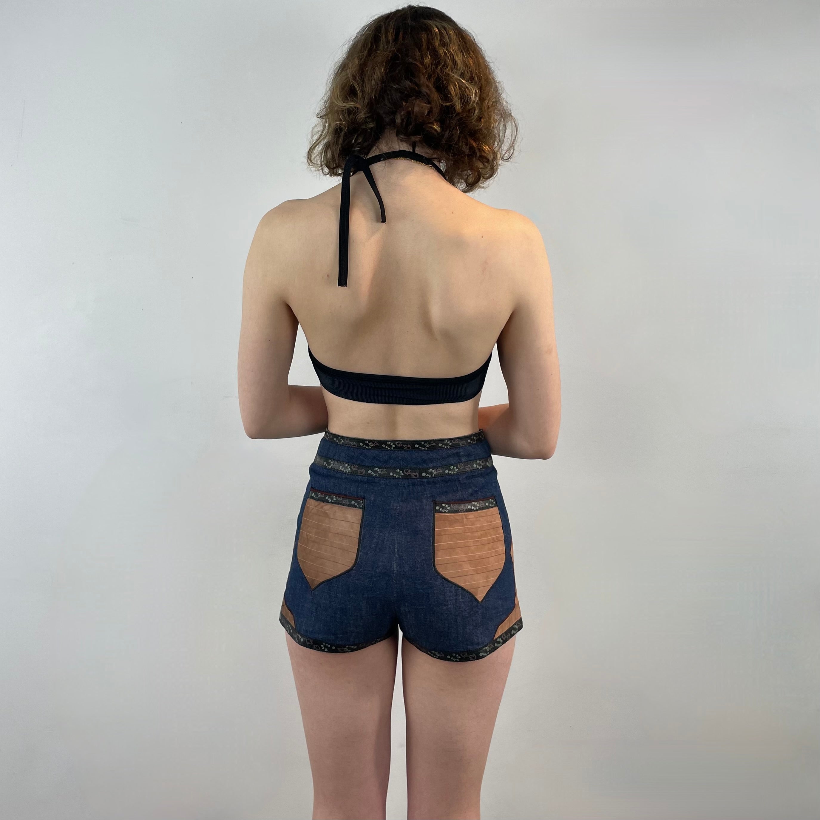Boheme Vintage 1970s Roberto Cavalli denim and leather hot pants shorts with flower snap closures and leather appliqué details.