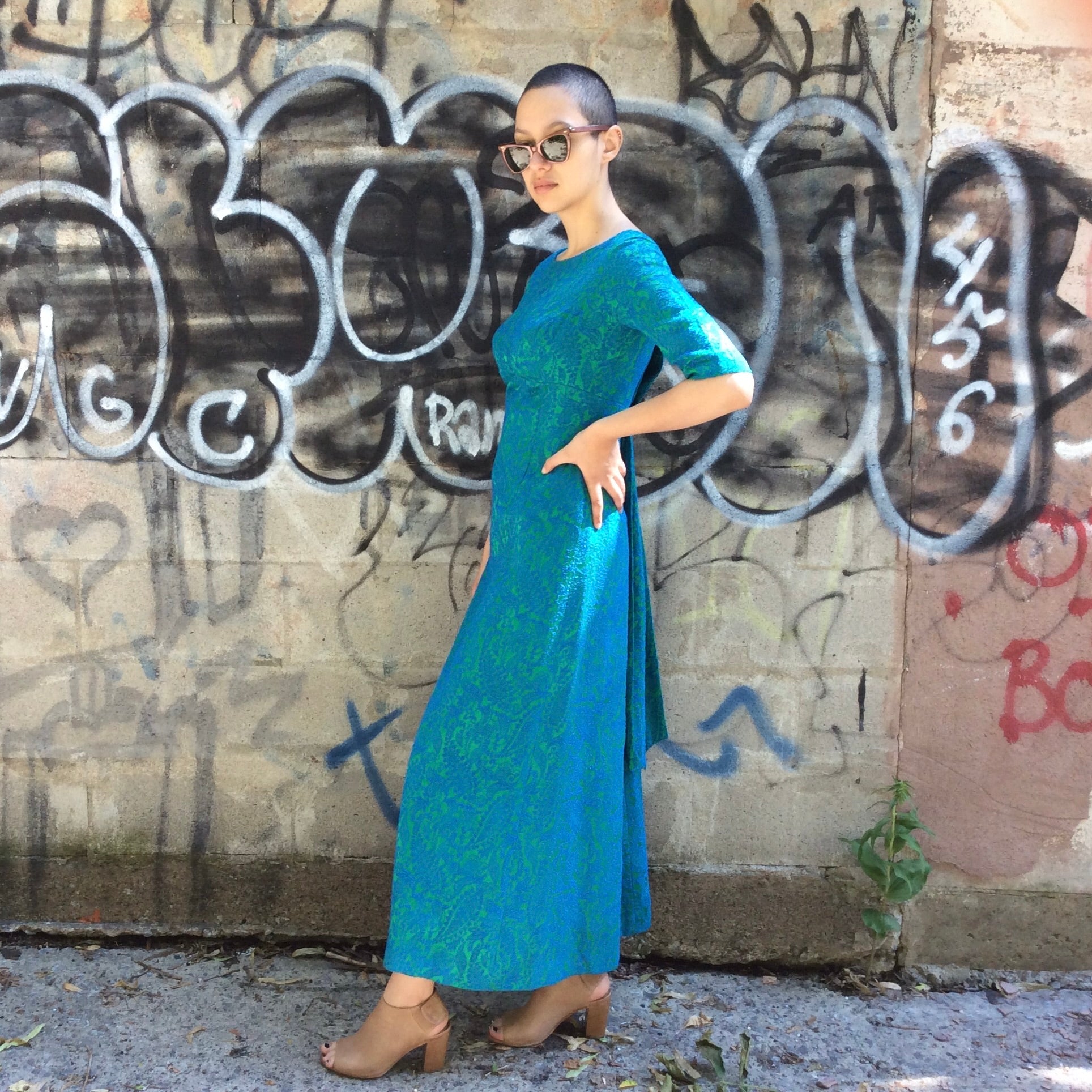 Side of Vintage 1960s blue and green brocade ankle-length evening dress with empire waist and low back detail, photographed in Montreal for Boheme Vintage – https://bohemevintage.com
– Montreal vintage fashion boutique.