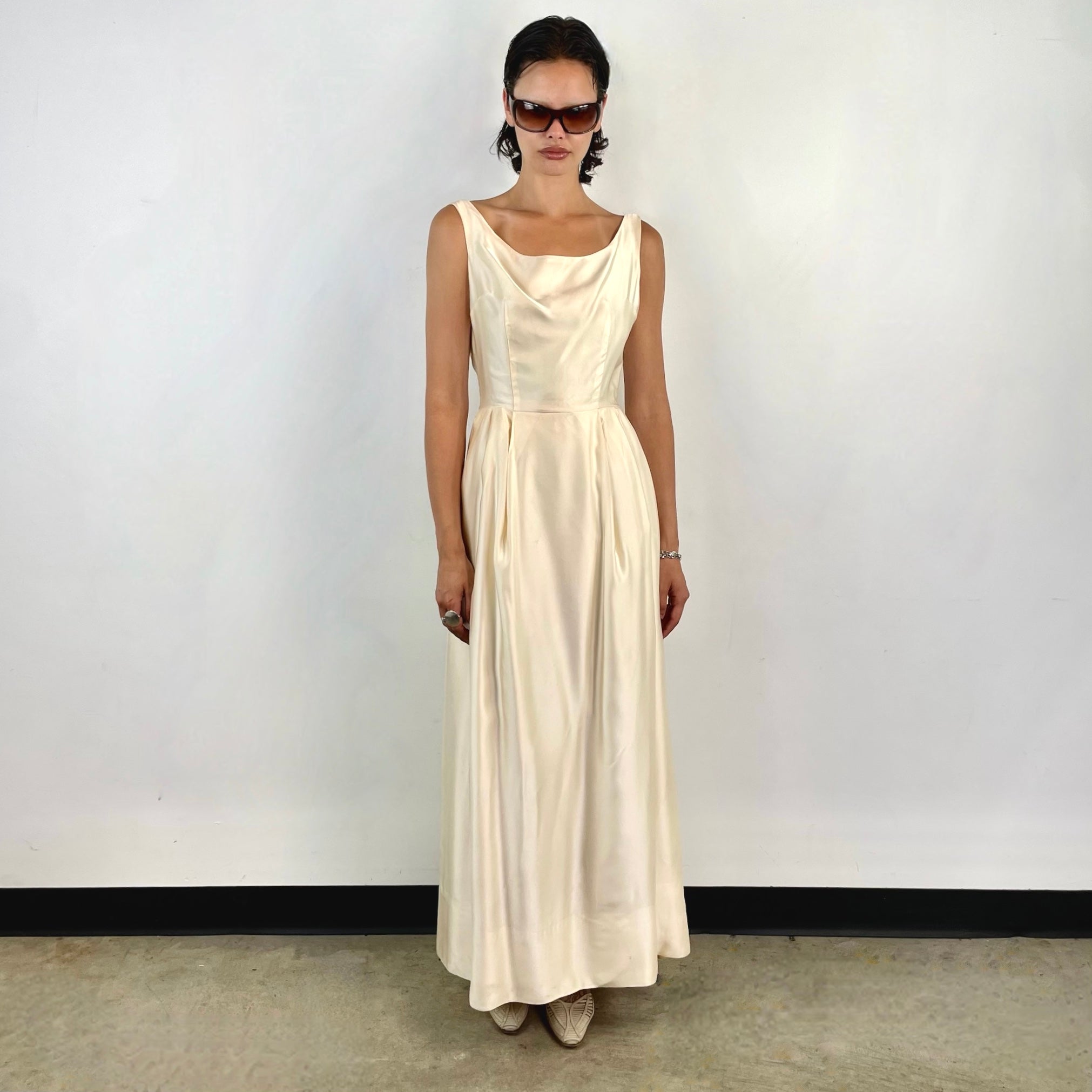 Boheme Vintage 1970s ivory satin gown with open back, pleated skirt, and fitted bodice.