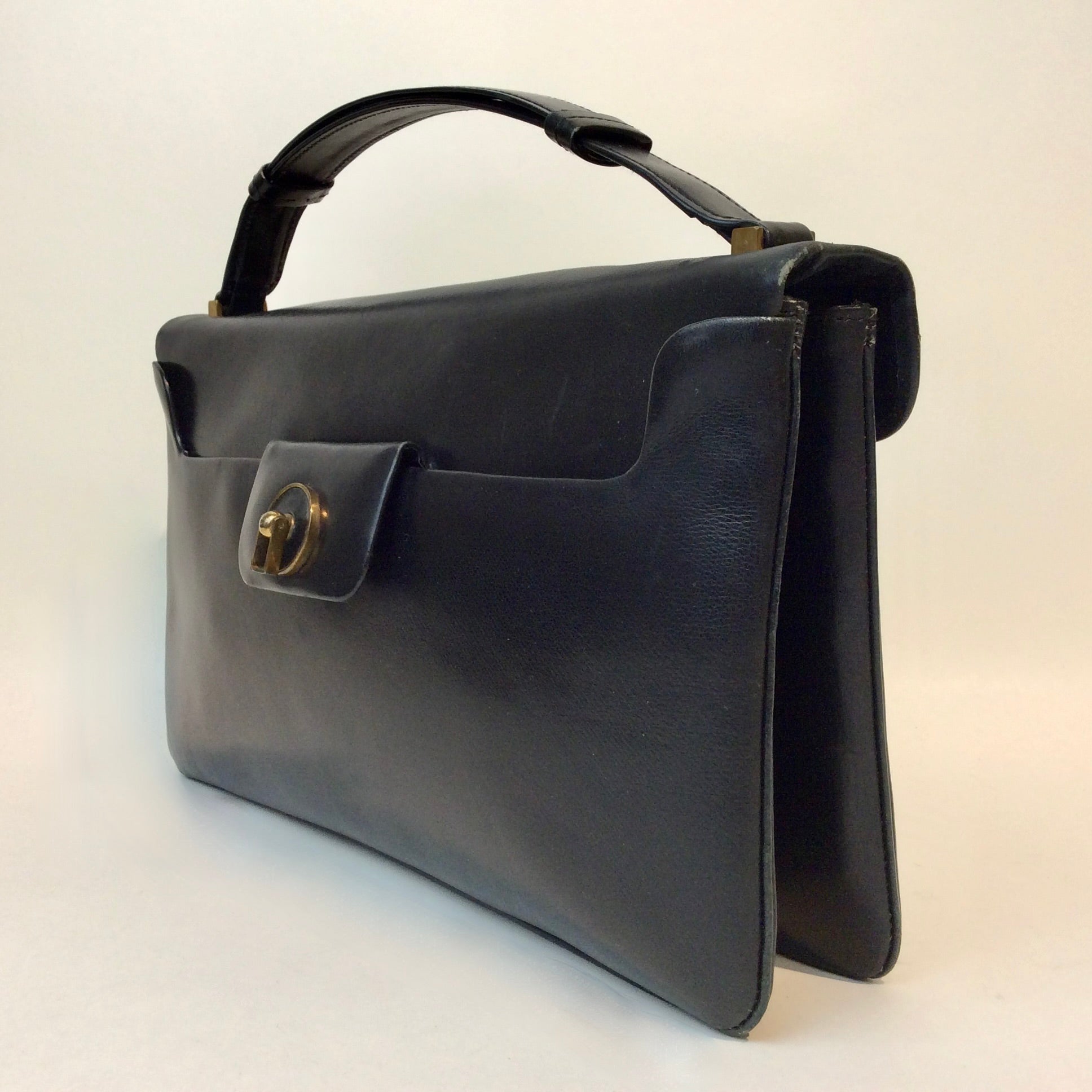 Vintage Art Deco leather handbag with unique closure and gold-tone hardware, available at Boheme Vintage, Montreal — bohemevintage.com