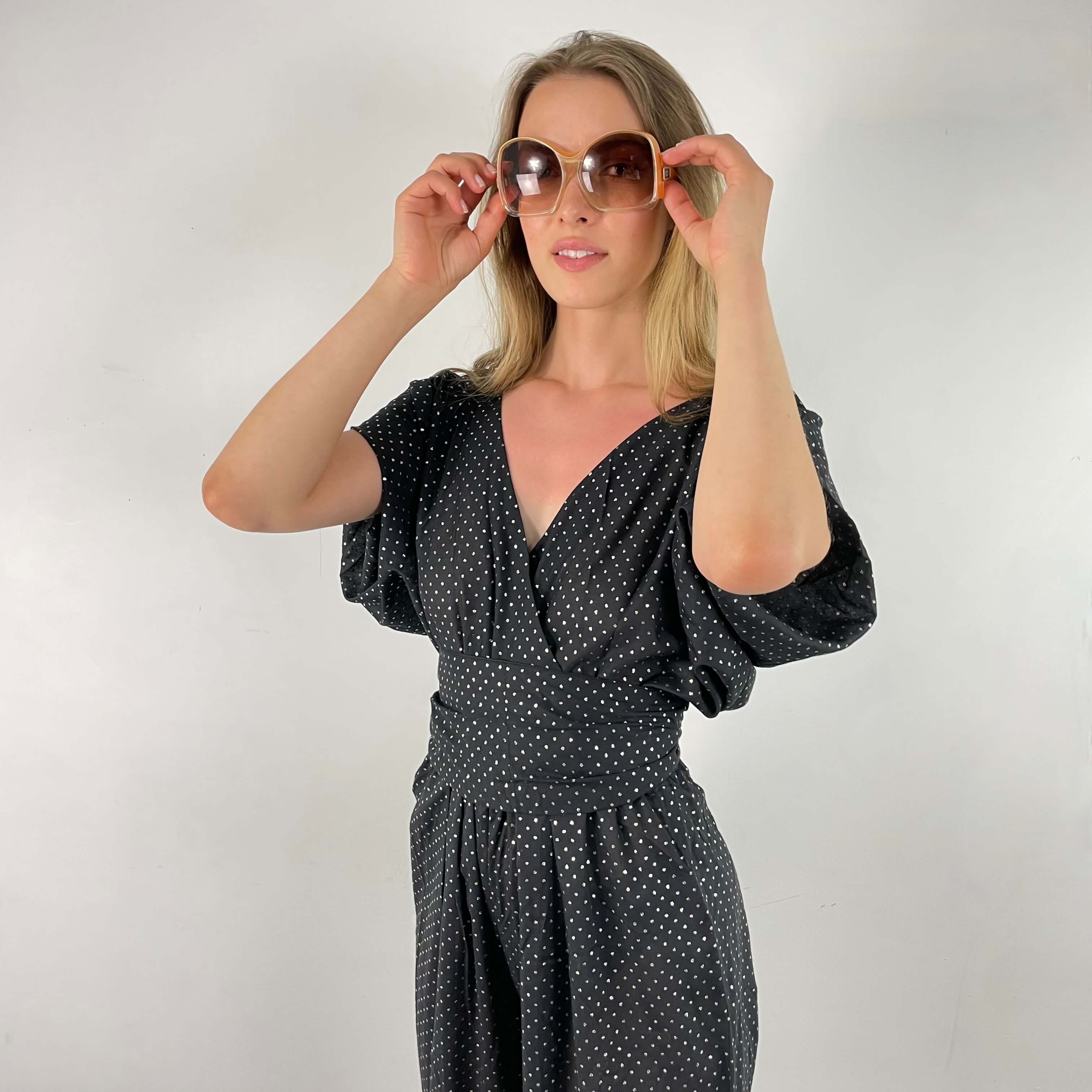 Close up view of front and side of 1980s Gold Dotted Black Jumpsuit Size Small-Medium sold at bohemevintage.com Montreal