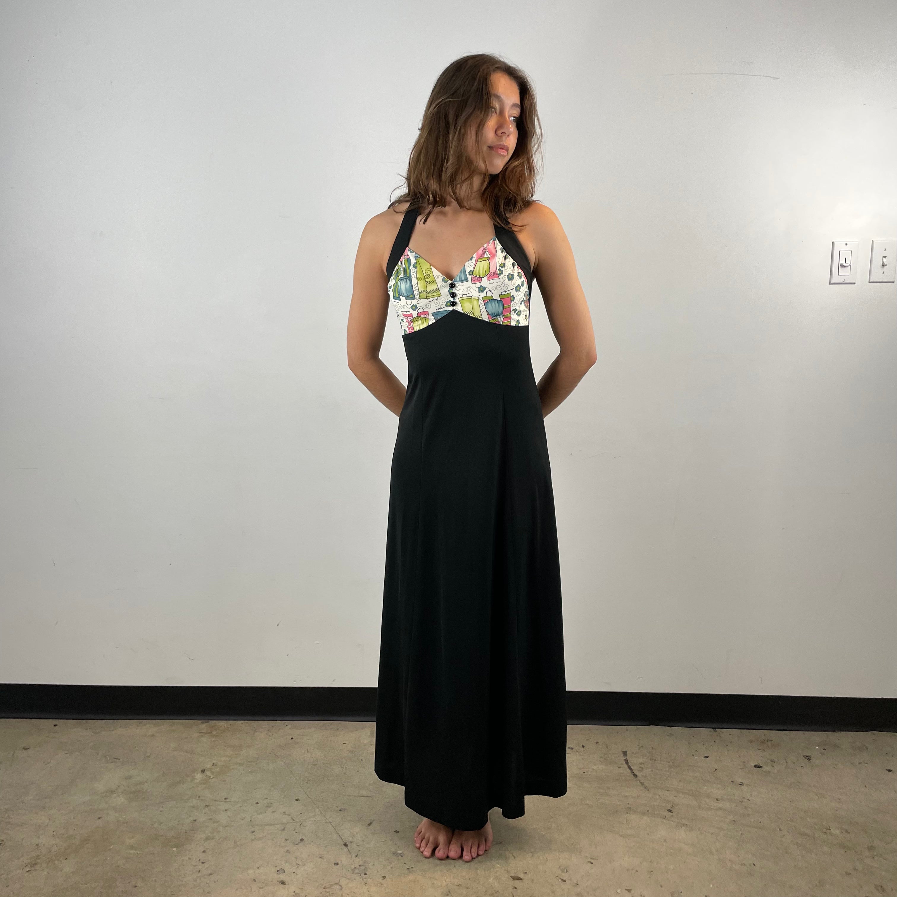 Front View of Boheme Vintage 1970s handmade black halter maxi dress with empire waist and patterned bust.