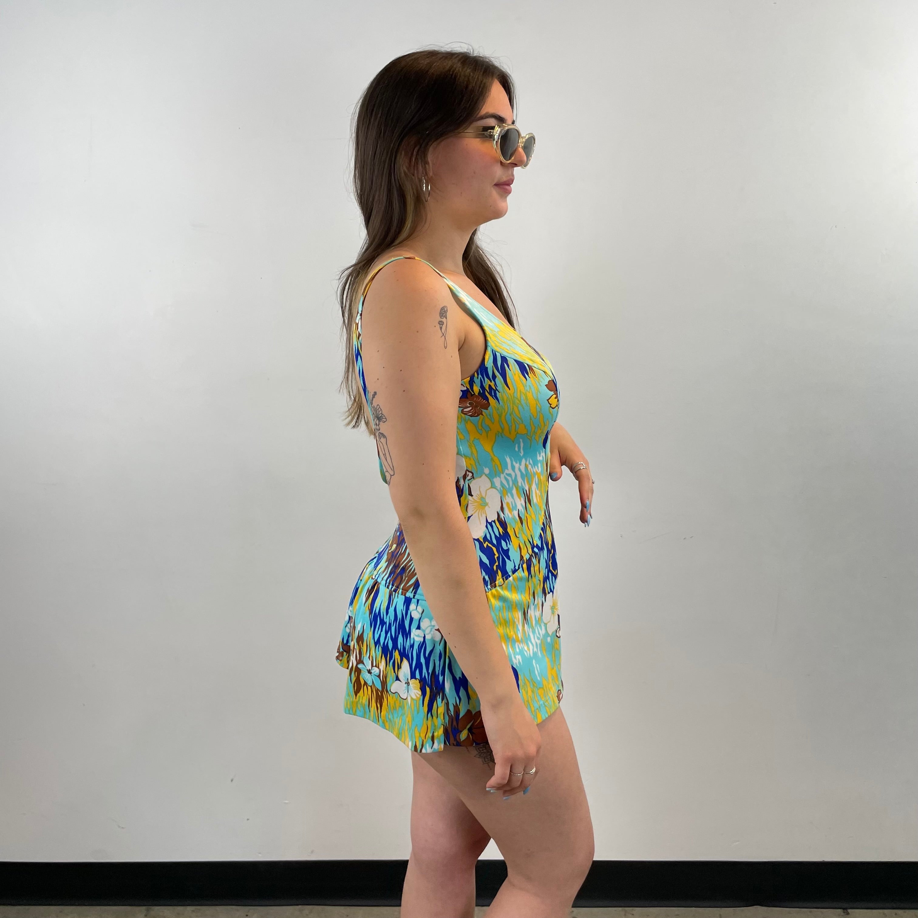 Boheme Vintage 1970s bold print skirted one-piece swimsuit with plunging V-neck, open back, and built-in mini skirt.