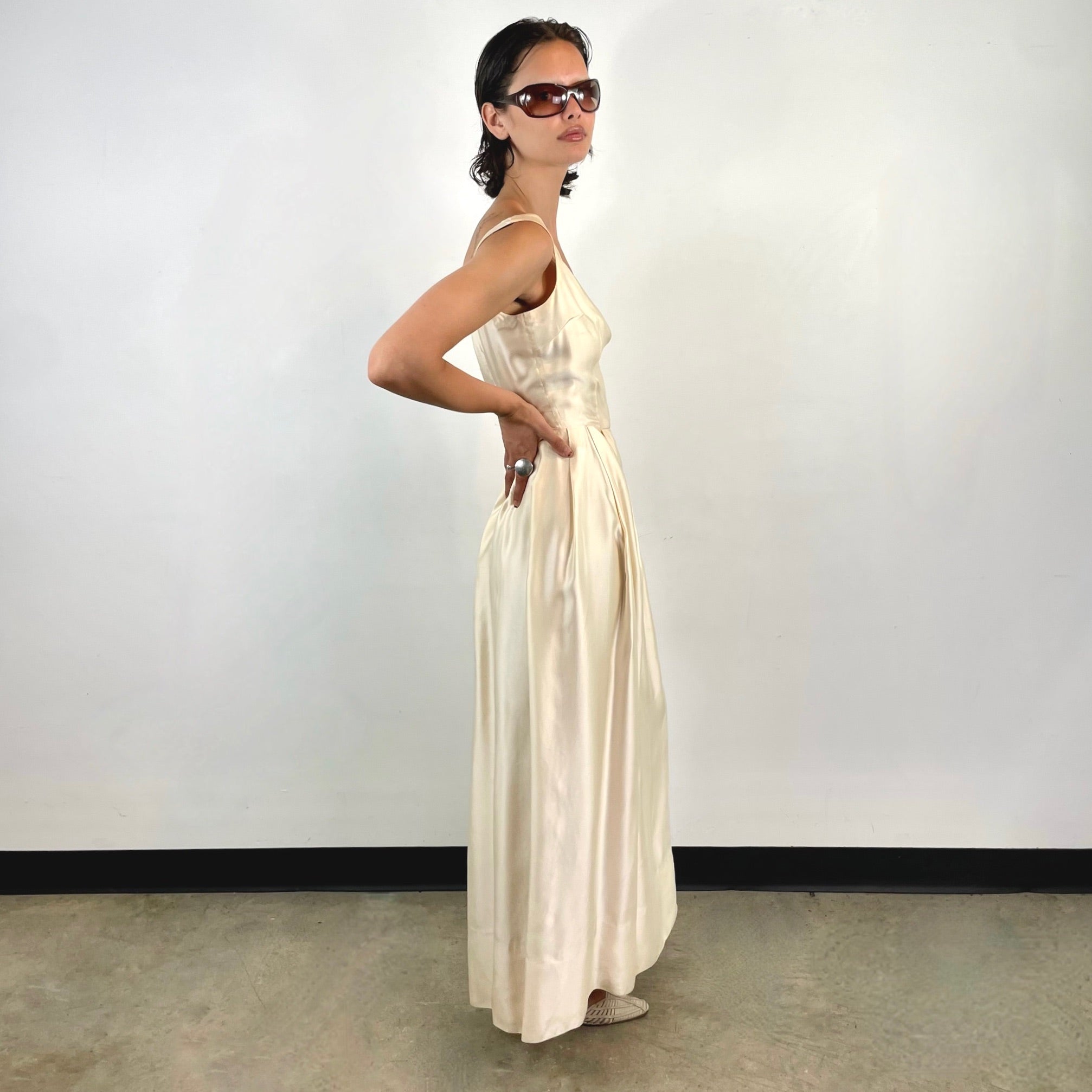 Boheme Vintage 1970s ivory satin gown with open back, pleated skirt, and fitted bodice.