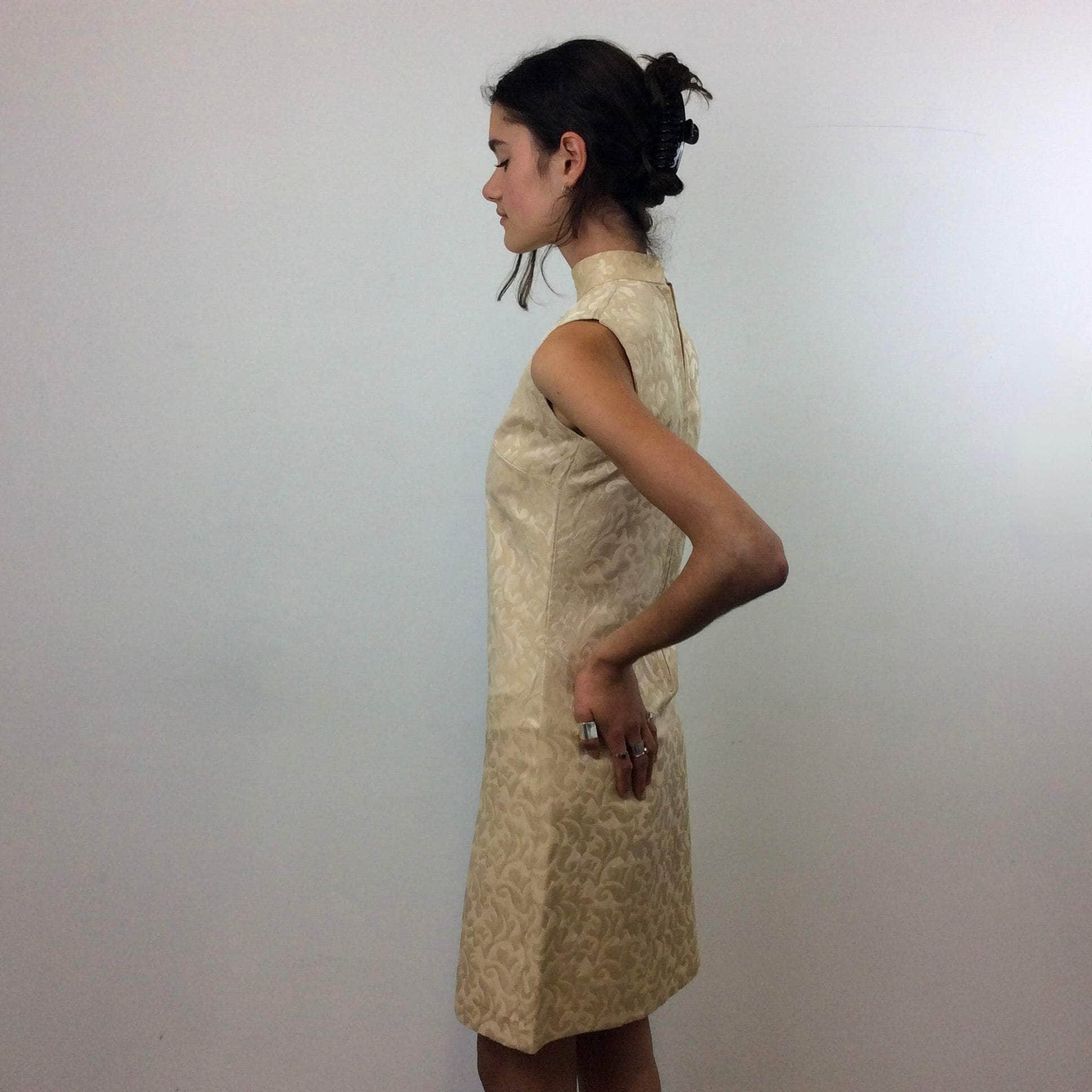 Side view of 1960s Beige Brocade Sleeveless Satin Shift Dress Small. Sold by Bohème Vintage. Montreal.