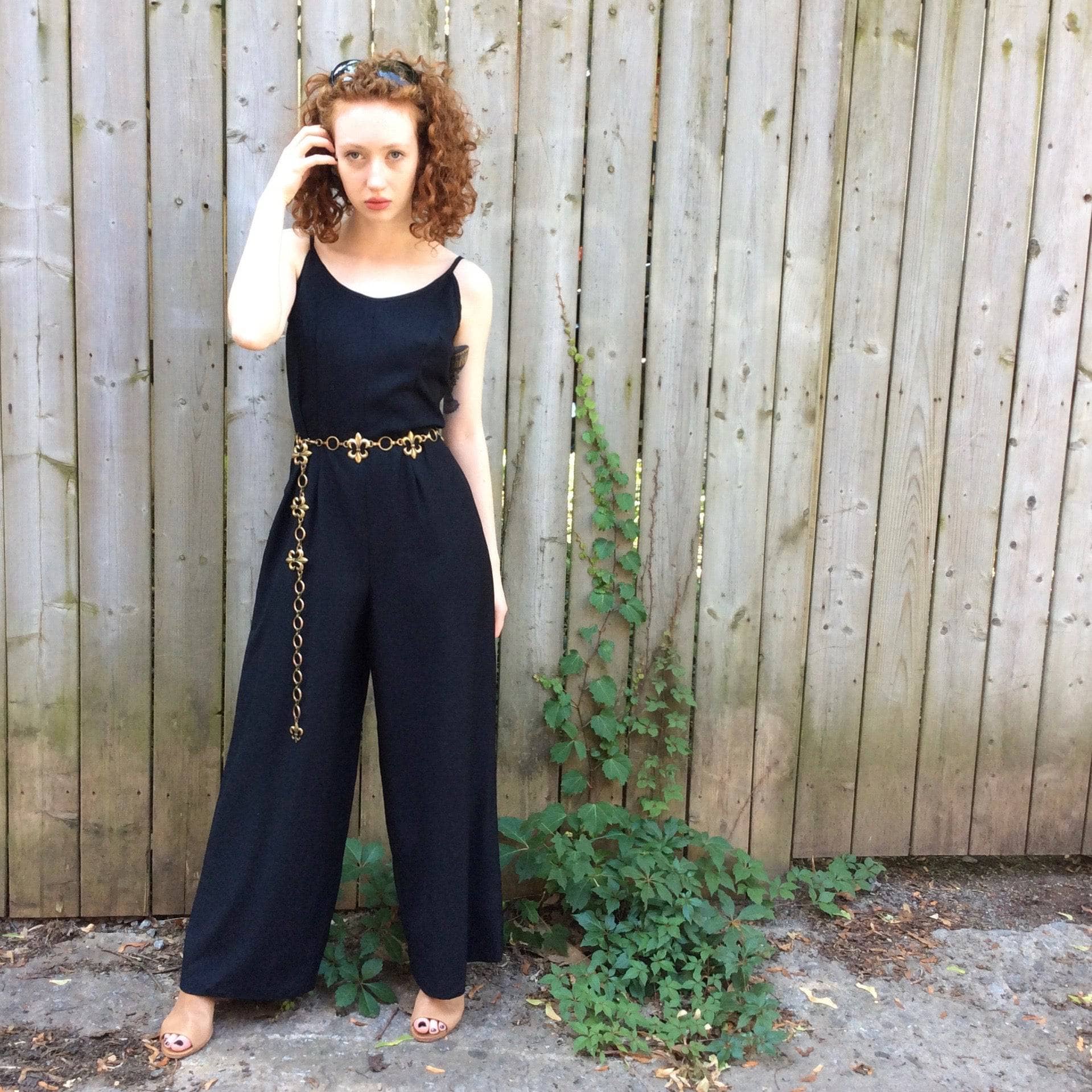 Front View of Boheme Vintage 1980s black wide-leg jumpsuit with fitted bodice, adjustable straps, and flowing silhouette.