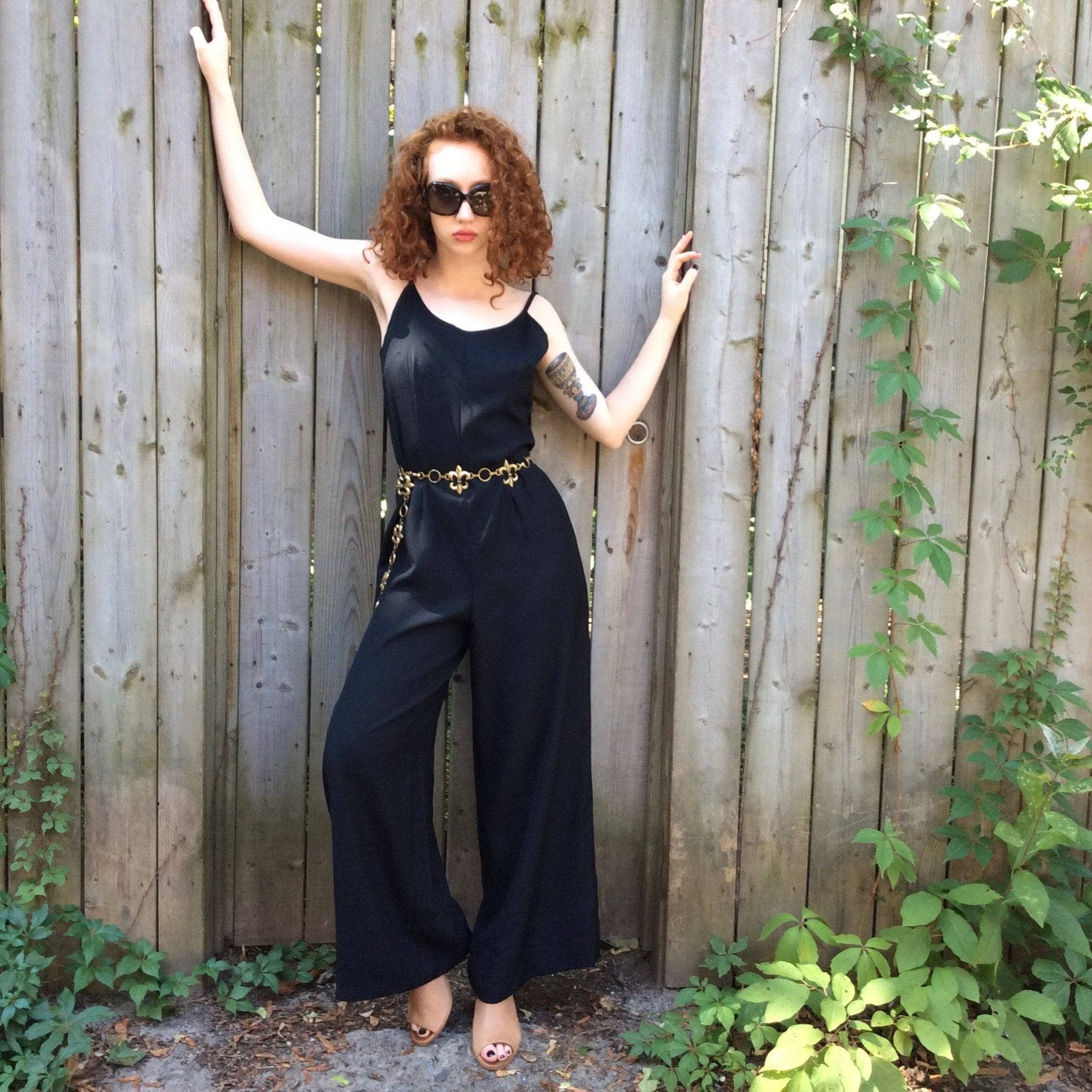 Front View of Boheme Vintage 1980s black wide-leg jumpsuit with fitted bodice, adjustable straps, and flowing silhouette. 