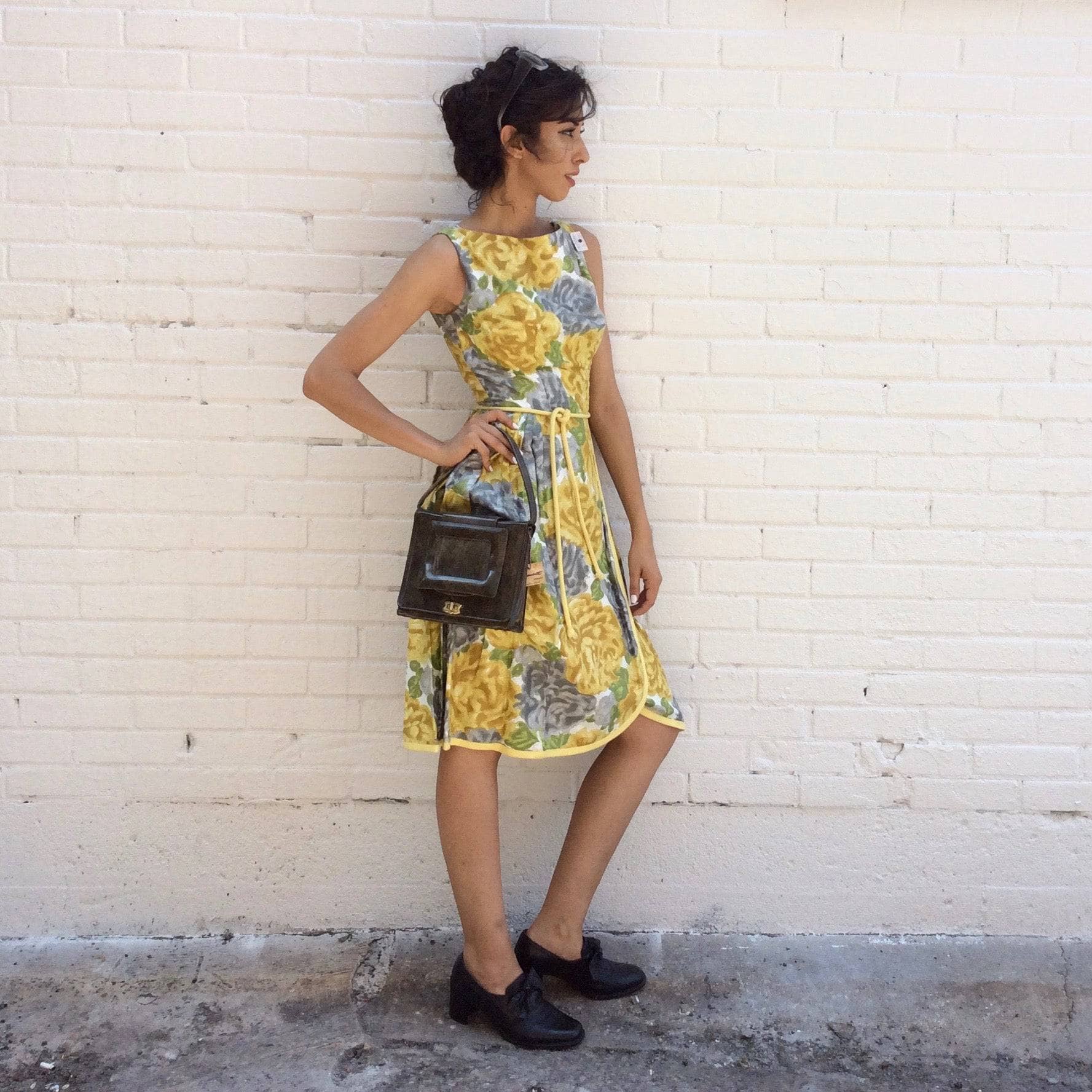 Side view of 1950s Yellow Floral Cotton Dress Size Small  model is wearing 1960s Pillbox Handbag  both sold by bohemevintage.com Montreal 